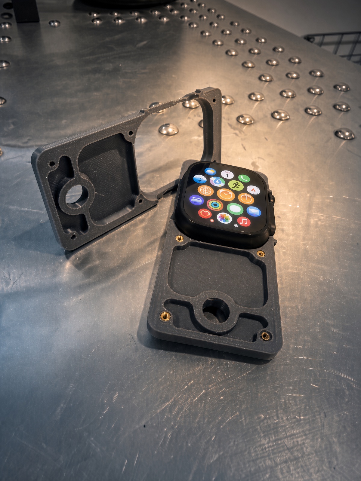 Unwrist case open on a desk, Apple Watch Ultra seated in one half, the other half beside it.